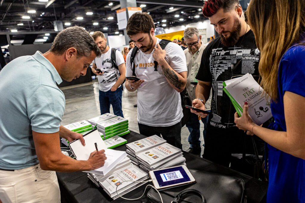 Saifedean Ammous signs copies of his book at the Bitcoin Conference